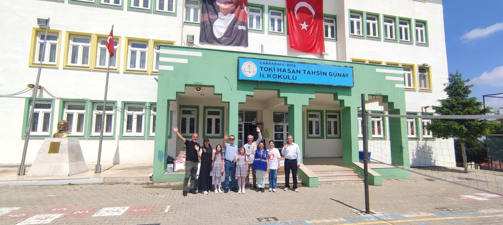 TOKİ Hasan Tahsin Günay İlkokulu'nun önünde dernek ekibi, öğretmenler ve öğrenciler